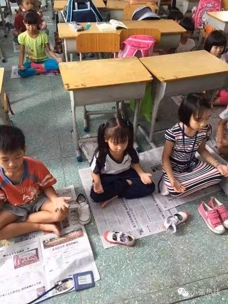 Trong những bức ảnh học sinh ngồi thiền được chụp lại từ đài truyền hình ở Phật Sơn, các em học sinh ngồi trên mặt đất, khoanh chân, nhắm mắt, thả lòng tay giống như các nhà sư. (Nguồn: CCTVNews).