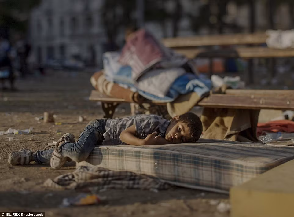 Abdullah, 5 tuổi ngủ trên một tấm nệm bẩn thỉu bên ngoài nhà ga trung tâm ở Belgrade. Cậu bé di cư 5 tuổi này hàng ngày vẫn còn bị sốc và gặp ác mộng vì đã phải chứng kiến cảnh em gái mình bị giết hại tại nhà ở Daraa, Syria.