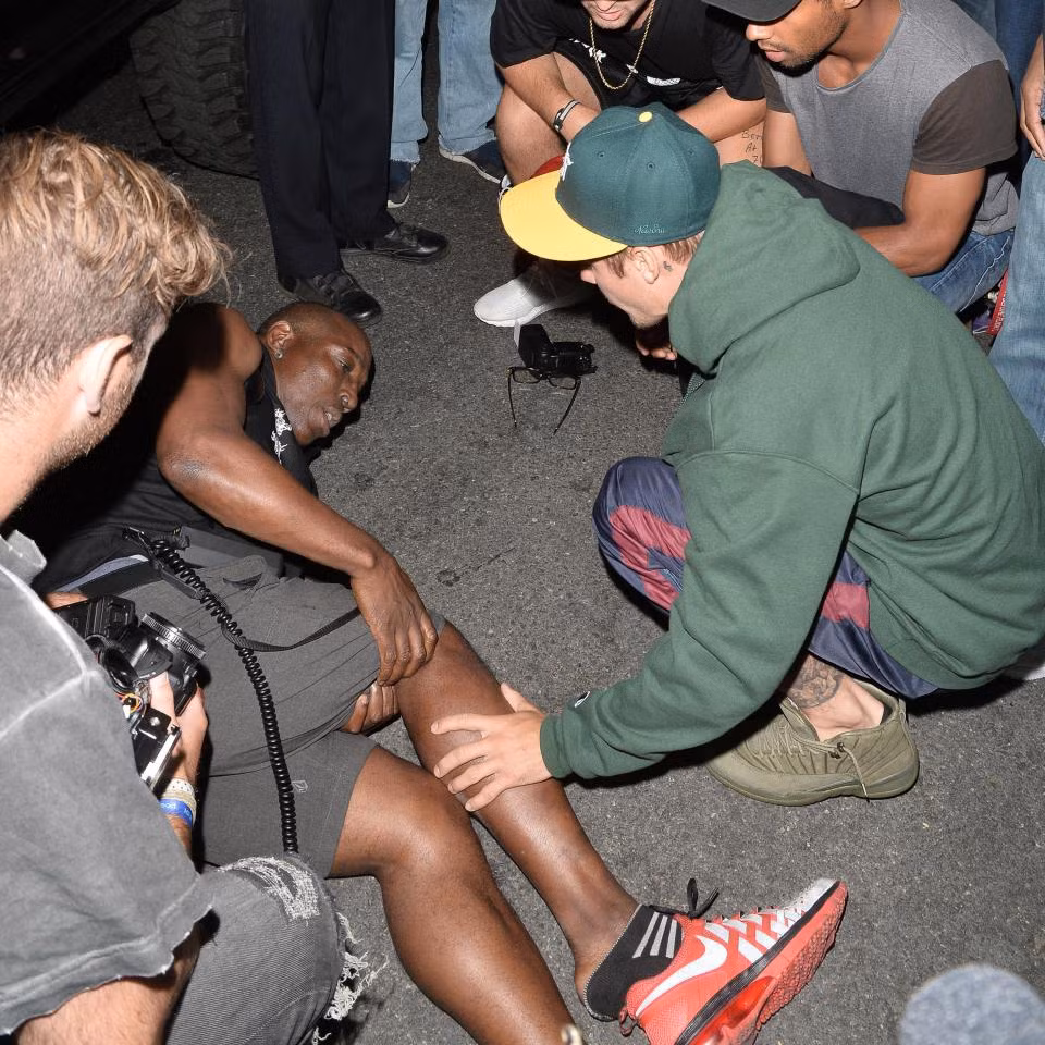 Justin Bieber tỏ ra rất ân cần với nạn nhân, thăm hỏi anh này trong thời gian đợi xe cấp cứu tới. (Ảnh: Splash News)