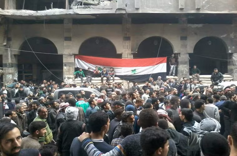“Hôm nay, một sự kiện quan trọng trong lịch sử đất nước Syria đã xảy ra. Lá cờ Syria tung bay trên tòa nhà ở Douma đánh dấu việc Quân đội Syria đã tái chiếm hoàn toàn thị trấn này cũng như Đông Ghouta”, Tướng Yury Yevtushenko phát biểu. Ảnh: AMN.