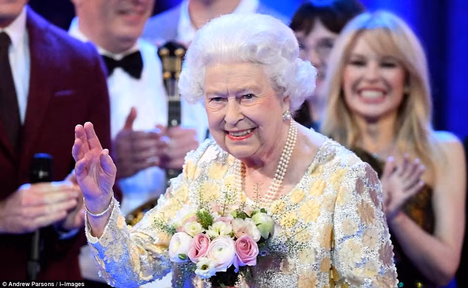 Nữ hoàng Anh Elizabeth II cầm bó hoa trên tay khi vẫy chào mọi người vào cuối buổi hòa nhạc.