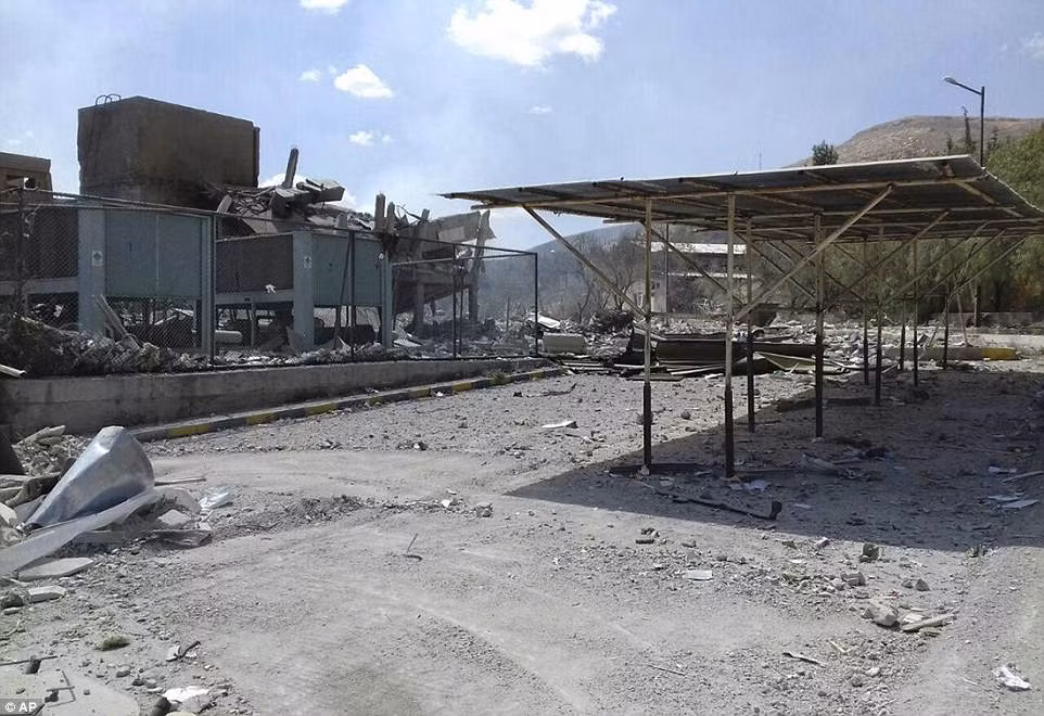 Đoạn video được chiếu trên kênh truyền hình Al-Ikhbariya (Syria) cho thấy đống đổ nát bên ngoài tòa nhà trung tâm bị phá hủy và chiếc xe bị đốt cháy. Ảnh: AP.