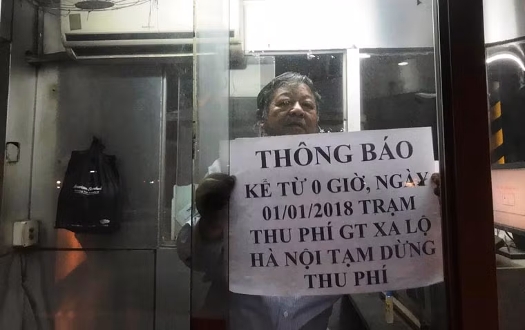 Nhân viên bắt đầu dán thông báo về việc tạm dừng thu phí BOT Xa lộ Hà Nội ngay tại các cabin thu phí.