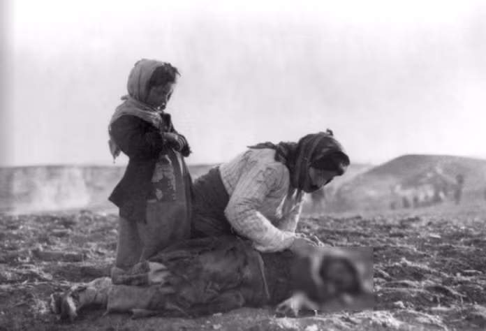 Một phụ nữ Armenia quỳ gối bên cạnh đứa con đã chết của cô ở Aleppo, Syria, vào khoảng năm 1915-1919.