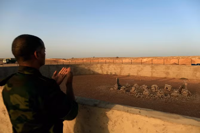 Binh sĩ Mặt trận Polisario cầu nguyện trước mộ của người sáng lập Mặt trận Polisario Mohammad Abdelaziz ở Tây Sahara.