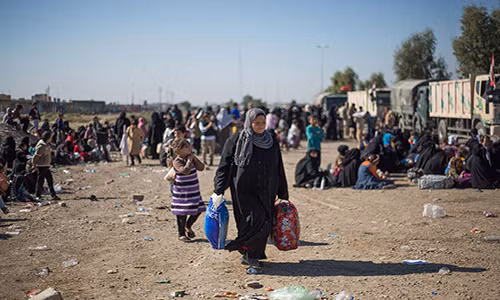 Một phụ nữ “tay xách nách mang” chờ được quân đội Iraq sắp xếp đưa tới những khu trại dành cho người dân sơ tán ở vùng ngoại ô phía đông thành phố Mosul. Họ có thể được đưa đi bằng xe buýt hoặc xe tải,...