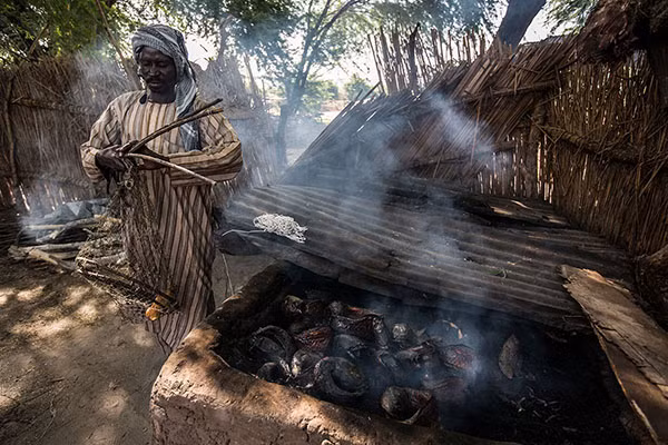 Oumar nướng cá để đem bán.