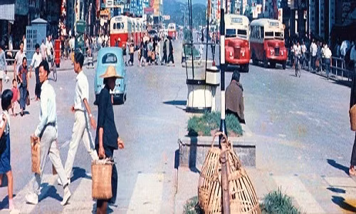 Một con đường tấp nập người và xe cộ ở Hong Kong năm 1960.