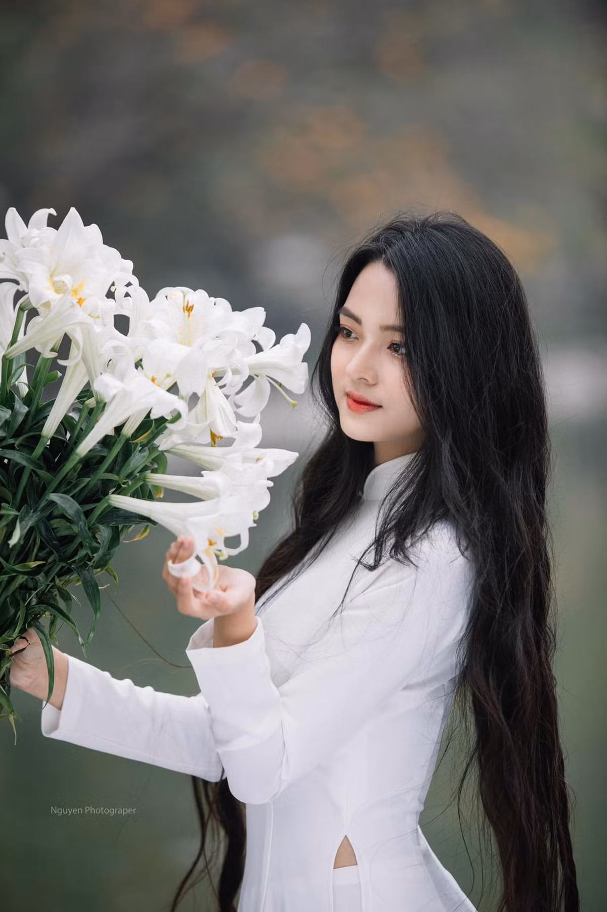 Mới đây nàng hot girl đất Quảng Nam gây ấn tượng khi cho ra mắt bộ ảnh áo dài trắng bên hoa loa kèn cùng mái tóc đen suôn dài.