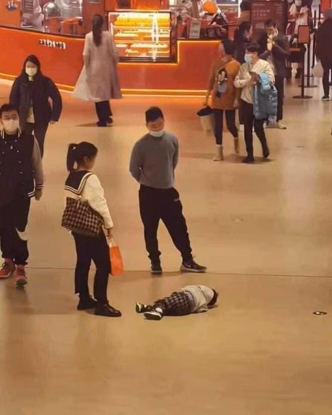 Khi con nằm ăn vạ và bố mẹ đứng nhìn xem ai lì hơn ai.