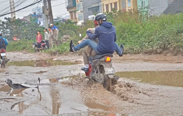 Theo ghi nhận của PV, vào giờ cao điểm các phương tiện lưu thông qua đây rất lộn xộn do tránh những vũng nước. Nhiều người không dám đi qua mà phải xuống dắt xe. Ảnh: Ở giữa đường xuất hiện những chiếc ổ voi đầy bùn đất.