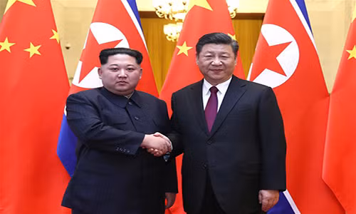 Lãnh đạo Triều Tiên Kim Jong-un (trái) bắt tay Chủ tịch Trung Quốc Tập Cận Bình trong cuộc gặp tại thủ đô Bắc Kinh. Ảnh: THX.