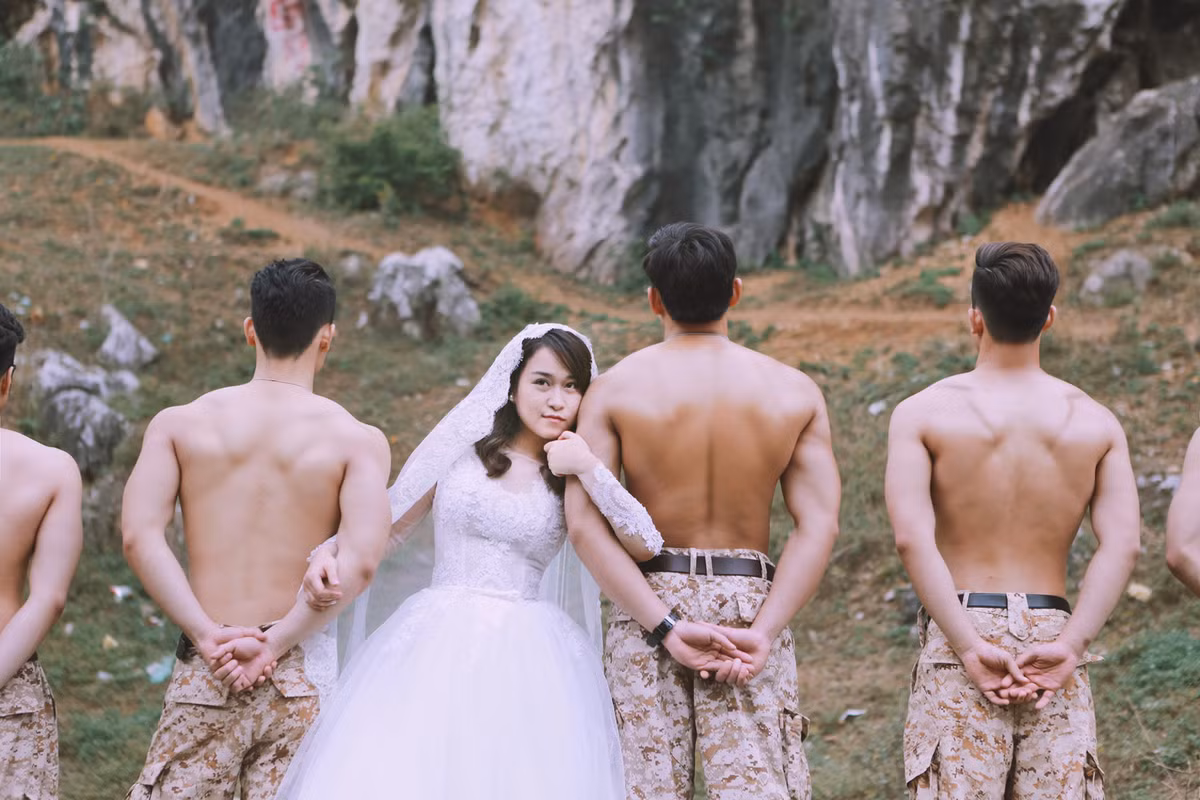 Bộ ảnh cưới độc đáo này còn có sự xuất hiện, trợ giúp của một dàn các anh chàng bảnh trai, cơ bắp, hóa thân thành các nam quân nhân giống hệt trong phim phiên bản gốc. Ảnh: Hải Lê Cao.