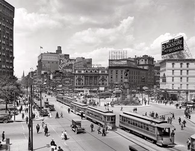 Đường phố Detroit, bang Michigan năm 1917 nhộn nhịp và đông vui với những chiếc xe điện qua lại liên tục và những biển hiệu quảng cáo được treo trên các tòa nhà.