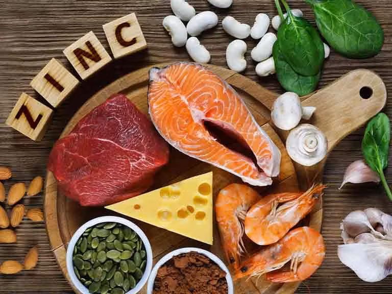 Thực phẩm giàu kẽm bao gồm: hạt bí ngô, hạt điều, thịt bò, gà tây, hạt quinoa, đậu lăng, hải sản như hàu và cua.