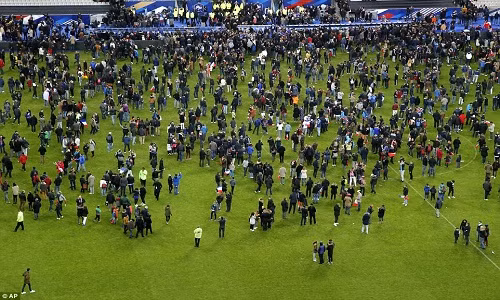Người hâm mộ bóng đá chạy ùa vào sân vận động Stade de France nơi diễn ra trận đấu bóng giữa Pháp-Đức sau khi vụ nổ xảy ra bên ngoài sân vận động này.