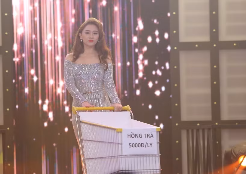 Tuy nhiên, điều thú vị hơn khi trong tay cô nữ hoàng xinh đẹp ấy là chiếc xe đẩy siêu thị cùng bảng giá "hồng trà 5000đ/ly".