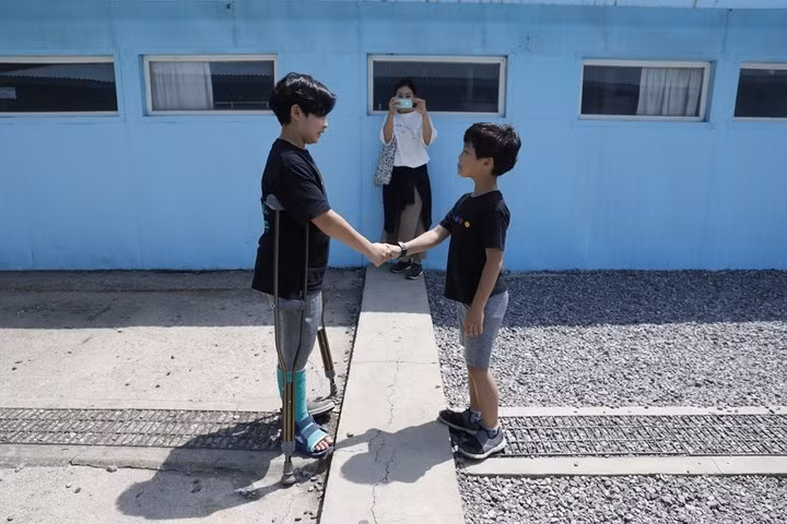 Các du khách đều tỏ ra thích thú đứng ở đường phân giới và bắt tay nhau như cách lãnh đạo liên Triều đã làm. Ảnh: Hani.
