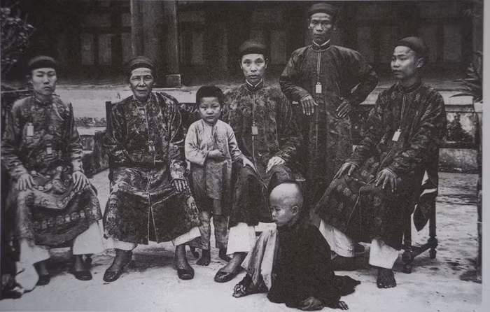 2 thái giám nhỏ tuổi và các thái giám trưởng thành trong Kinh thành Huế. Ảnh: Pierre Marie Alexis Dieulefils