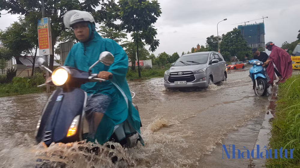 Nhiều người vẫn liều mình đi xe qua đoạn đường ngập sâu ở đường ven Đại lộ Thăng Long.