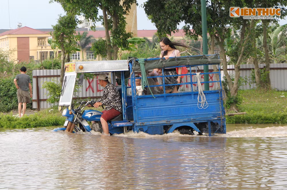 Xe 3 bánh dịch vụ liên tục đưa đón người ra vào tòa nhà qua vùng nước ngập.