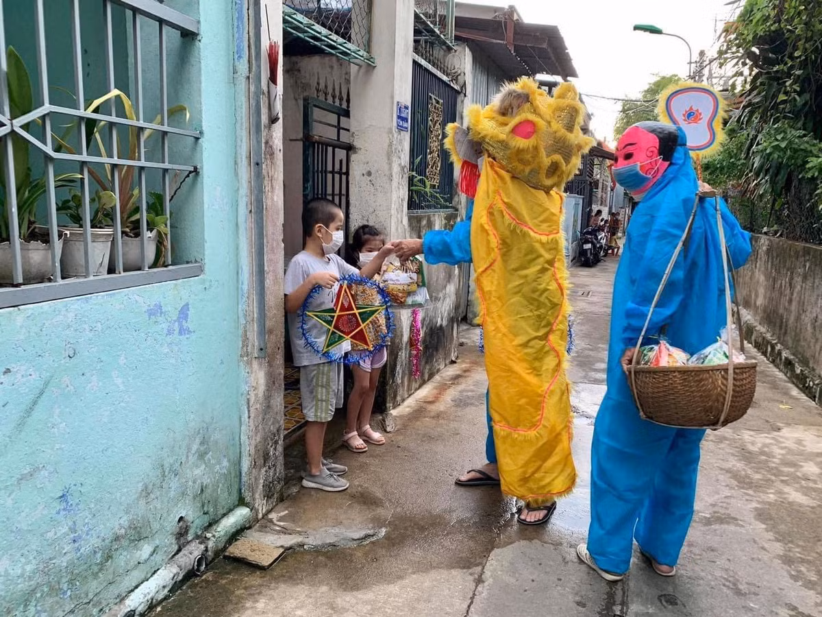 Thay vì khoác lên mình trang phục múa lân hay ông địa đúng nghĩa, những tình nguyện viên lại khoác lên mình đồ bảo hộ chống dịch. Ảnh: Trương Vĩnh Đặng