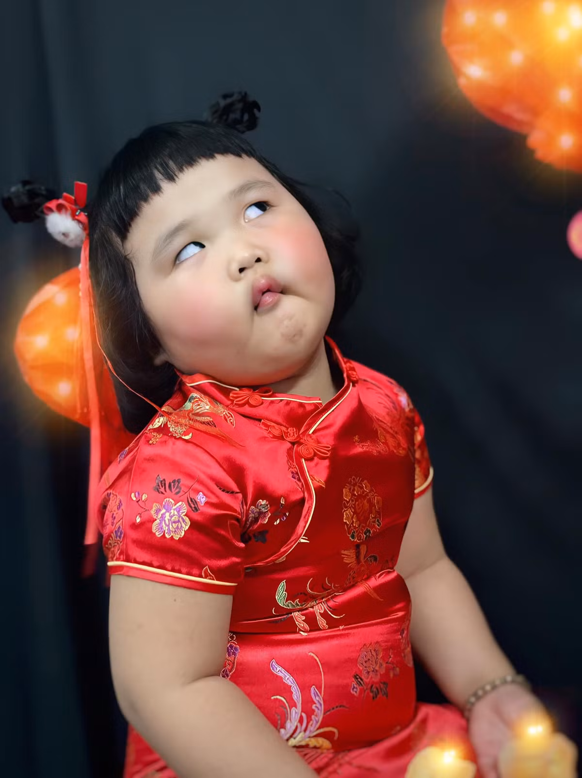Khoác trên mình bộ đồ màu đỏ, bé gái trông vô cùng đáng yêu khi sở hữu khuôn mặt mũm mĩm, làn da trắng cùng tóc mái ngố.