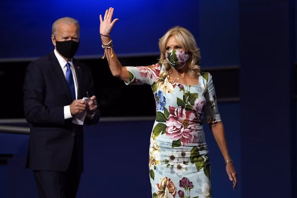 Mỗi khi xuất hiện, bà Biden luôn trông trẻ hơn nhiều so với tuổi thật nhờ cách chọn những bộ váy màu sáng, thanh nhã. Bà Jill Biden diện váy hoa lá đồng điệu với khẩu trang đến từ hãng Dolce &amp; Gabbana khi xuất hiện cùng chồng.