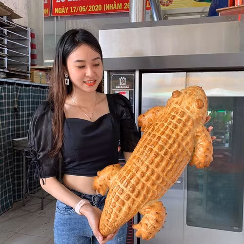 Mỗi ổ bánh mì ngọt hình cá sấu nặng khoảng 2kg, chiều dài 60-70cm, giá bán 50 nghìn đồng. Mỗi ngày, tiệm bánh mì này làm được vài chục con, nướng ra đợt nào là bán hết đợt đó.