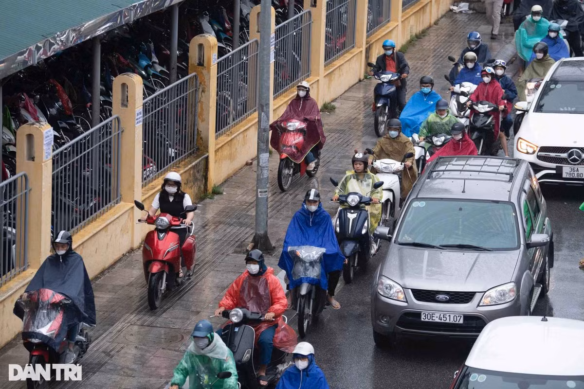 Hình ảnh người tham gia giao thông trùm kín áo khoác ấm, áo mưa khi đi đường trong buổi sáng đầu tuần.