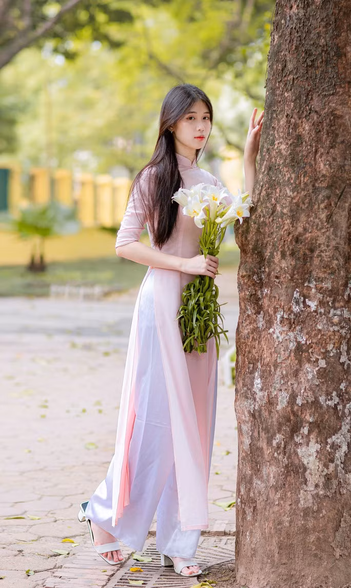 Nét đẹp dịu dàng của người con gái Hà thành bên bó hoa loa kèn trắng tinh khôi, tỏa hương thơm dịu dàng.