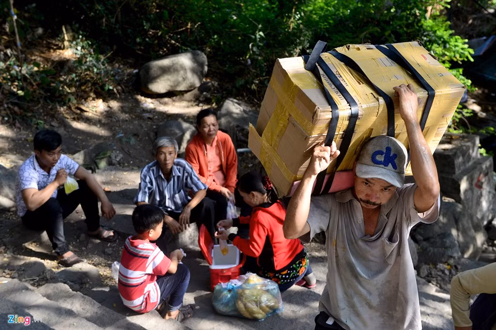 Trong dòng người hành hương đang cuốc bộ, ngồi nghỉ chân vì mệt thấp thoáng những phu khuân vác các kiện hàng nặng vượt dốc đá. Đây là công việc mưu sinh nơi cửa thiền mỗi ngày của họ.