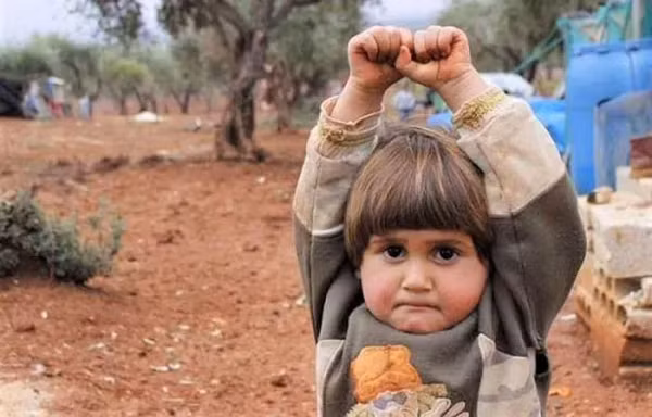  Bức ảnh một bé gái người Syria giơ tay sợ hãi khi nhìn thấy ống kính máy ảnh - vì nghĩ là một khẩu súng đã nói lên sự thật đau lòng và khốc liệt của chiến tranh tại Syria.