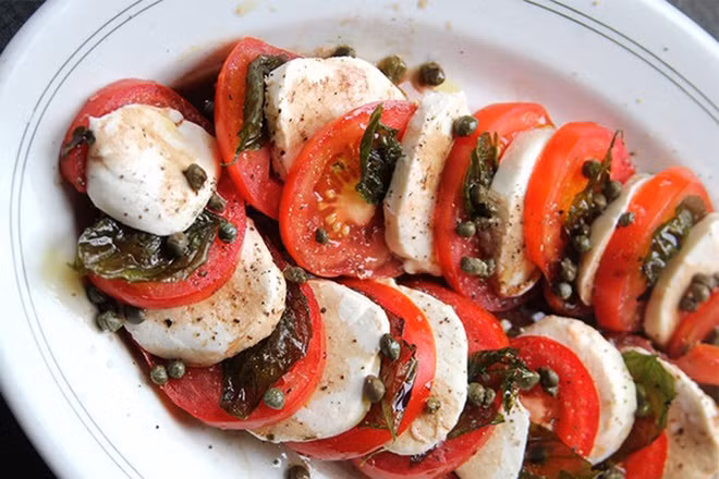 Caprese salad với hạt capers nướng và rau húng quế. Những hạt capers nướng mặn được sử dụng trong nhiều món ăn nhưng ngon nhất là trong món salad Caperse.