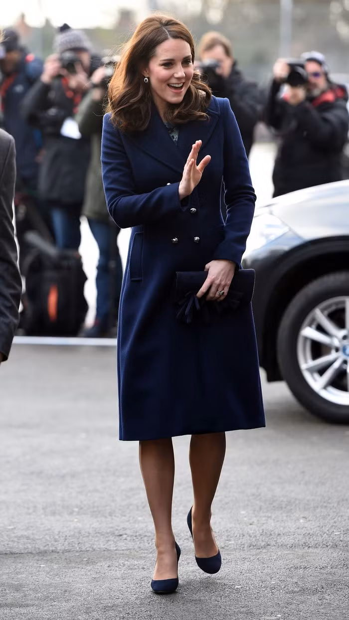 Chiếc áo choàng xanh navy, kết hợp cùng ví và giày cùng tông khiến Công nương Kate Middleton quý phái.