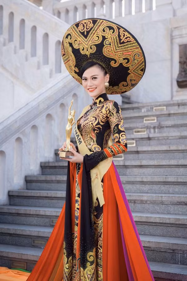 Bộ áo dài truyền thống do nhà thiết kế Tuấn Hải thực hiện với họa tiết rồng, trống đồng và hoa văn cung đình đã giúp Cao Thùy Linh giành giải Trang phục dân tộc đẹp nhất tại Hoa hậu Hòa bình 2014. Ảnh: Sao360.