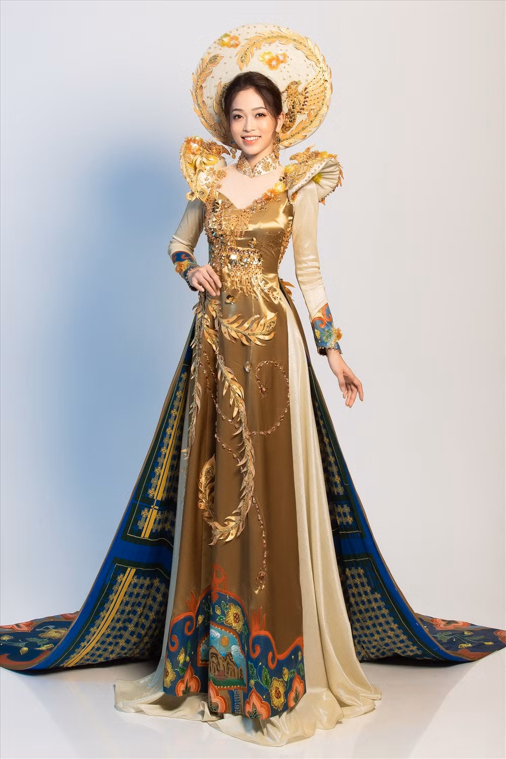 Tại cuộc thi Miss Grand International 2018, Á hậu Phương Nga chọn bộ quốc phục do NTK Khánh Shyna thực hiện. Bộ quốc phục này có tên gọi “Ngũ Phụng Tề Phi”, tông chủ đạo của bộ trang phục là màu vàng cung đình, được sử dụng với chất liệu gấm kết hợp với lụa truyền thống, mang ý tưởng về hình tượng ngũ phụng và pháp lam Huế. Ảnh: FBVN.