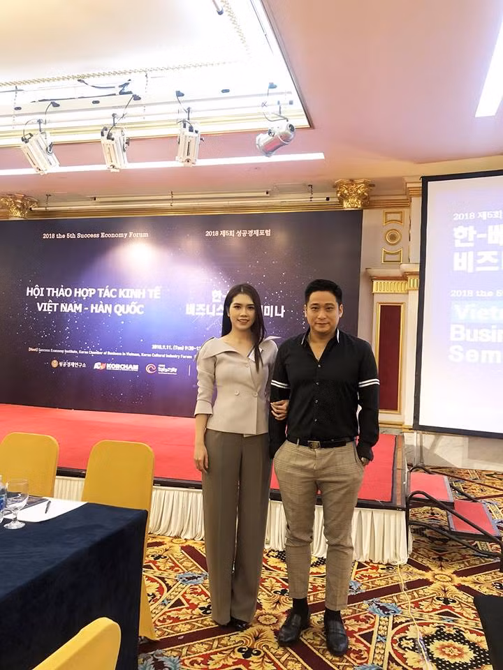 Minh Tiệp mặc áo đen, quần kẻ màu sáng lịch lãm sánh bước bên bà xã.