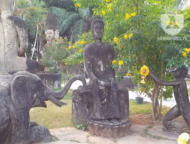 Tổ hợp tượng voi và tượng khỉ quỳ trước tượng Phật.