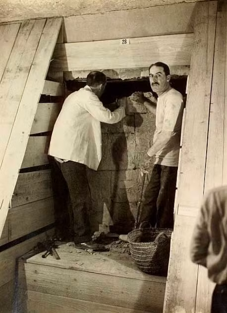 Howard Carter (bên trái ảnh) và huân tước Carnarvon (phải ảnh) cùng phá dỡ một bức tường ngăn cách Phòng chờ và Phòng chôn cất.