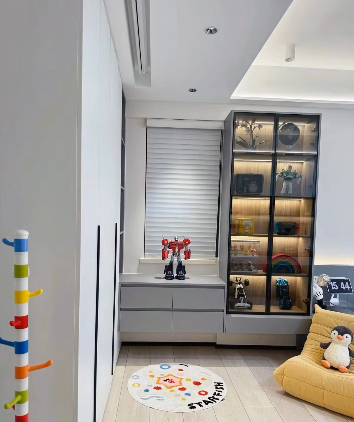 Vì căn phòng được sử dụng cho 2 bé nên nguyên tắc trang trí là phải làm thế nào để có thêm chỗ chứa đồ. Ngoài một dãy tủ âm tường, một tủ đựng đồ nổi cũng được bố trí ở đầu giường. 