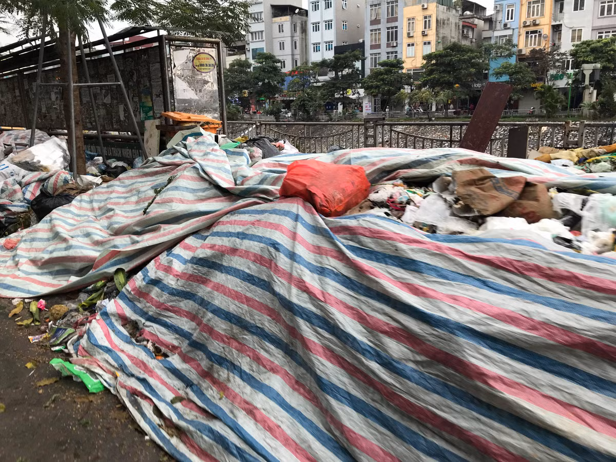 Người dân phải quây bạt kín lại để giảm tải ô nhiễm, mùi do rác thải bốc lên. 