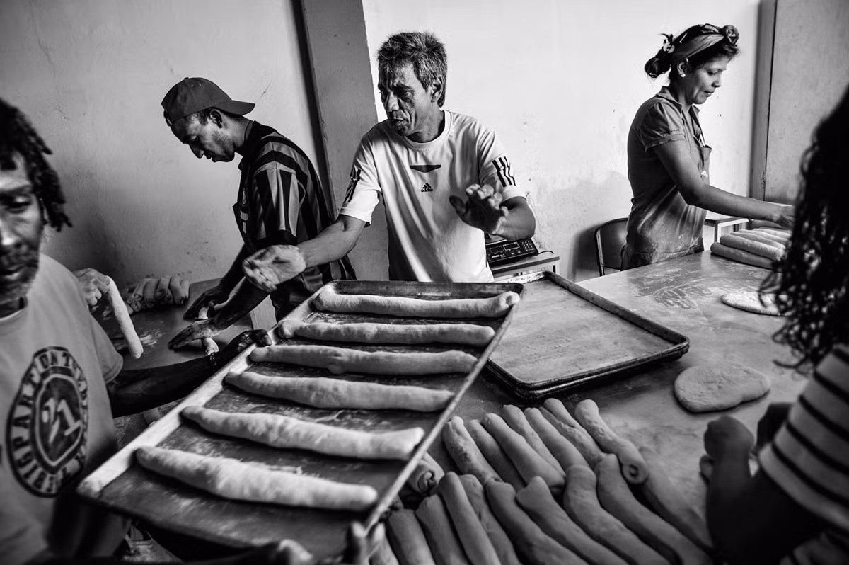 Người làm công đang tất bật làm bánh mì để bán với giá hỗ trợ cho mọi người. Hàng trăm người dân quốc gia Nam Mỹ thường đứng xếp hàng bên ngoài lò bánh mì này mỗi ngày.