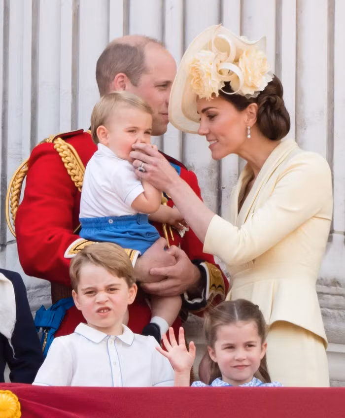 Hoàng tử William bế Louis trên ban công Cung điện Buckingham năm 2019.