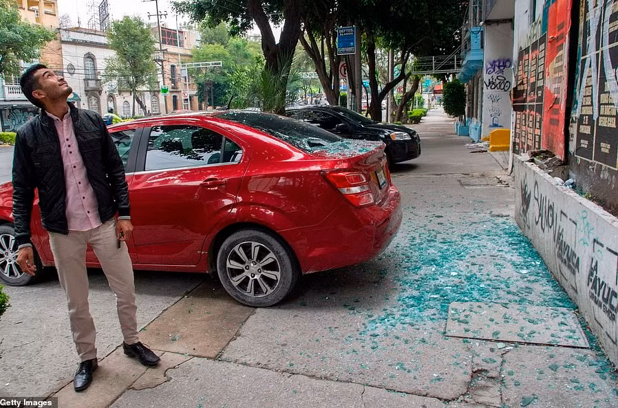 Cửa kính của một tòa nhà bị vỡ và rơi trúng chiếc ô tô phía dưới ở Mexico City.