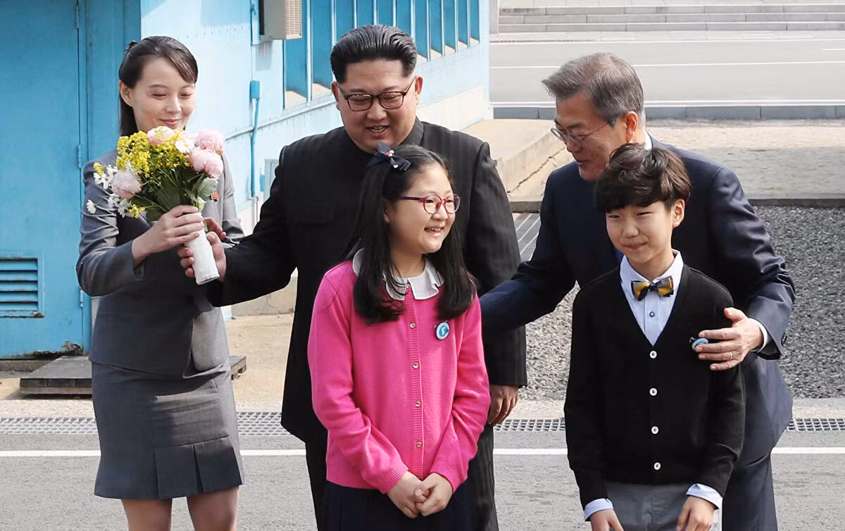 Theo Sputnik, bà Kim Yo-jong được coi là một nhân vật chính trị quyền lực ở Triều Tiên và là “cánh tay phải” bên cạnh nhà lãnh đạo Triều Tiên Kim Jong-un, tháp tùng ông Kim trong nhiều cuộc họp cấp cao, bao gồm Hội nghị thượng đỉnh với Tổng thống Mỹ Donald Trump và Tổng thống Hàn Quốc Moon Jae-in. Ảnh: Bà Kim Yo-jong (trái) cầm bó hoa khi nhà lãnh đạo Triều Tiên Kim Jong-un và Tổng thống Hàn Quốc Moon Jae-in chụp ảnh với các em nhỏ trước cuộc gặp thượng đỉnh tại Bàn Môn Điếm ngày 27/4/2018.