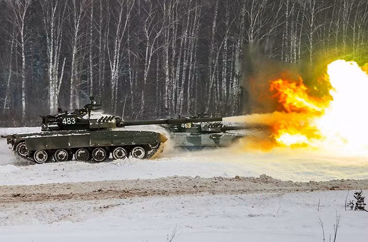 Hình ảnh dàn xe tăng T-80UD bảo vệ Moscow khai hỏa trong huấn luyện tác chiến mùa đông, đối với đạn phân mảnh như 3OF26 tầm bắn của T-80UD có thể lên đến 12.000m với pháo 2A46M. Nguồn ảnh: Bộ Quốc phòng Nga.