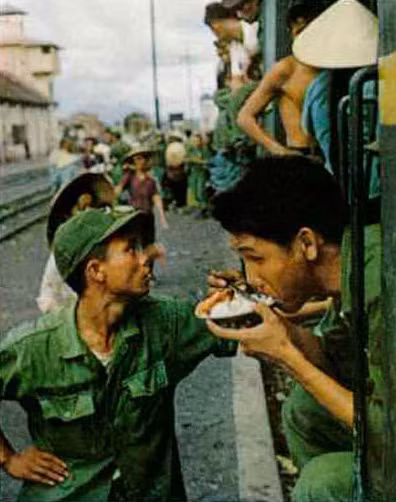 Bửa ăn vội vàng của người lính VNCH tại một nhà ga. Trên các đoàn tàu ở miền Nam Việt Nam trước 1975 không có toa ăn, hành khách phải tranh thủ ăn khi tàu dừng ở ga.