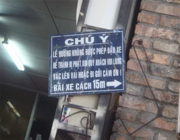 Tấm biển thông báo như "thách đố" khách hàng hoặc vác xe lên vai hoặc đi gửi xe vì lề đường không được phép đậu xe.