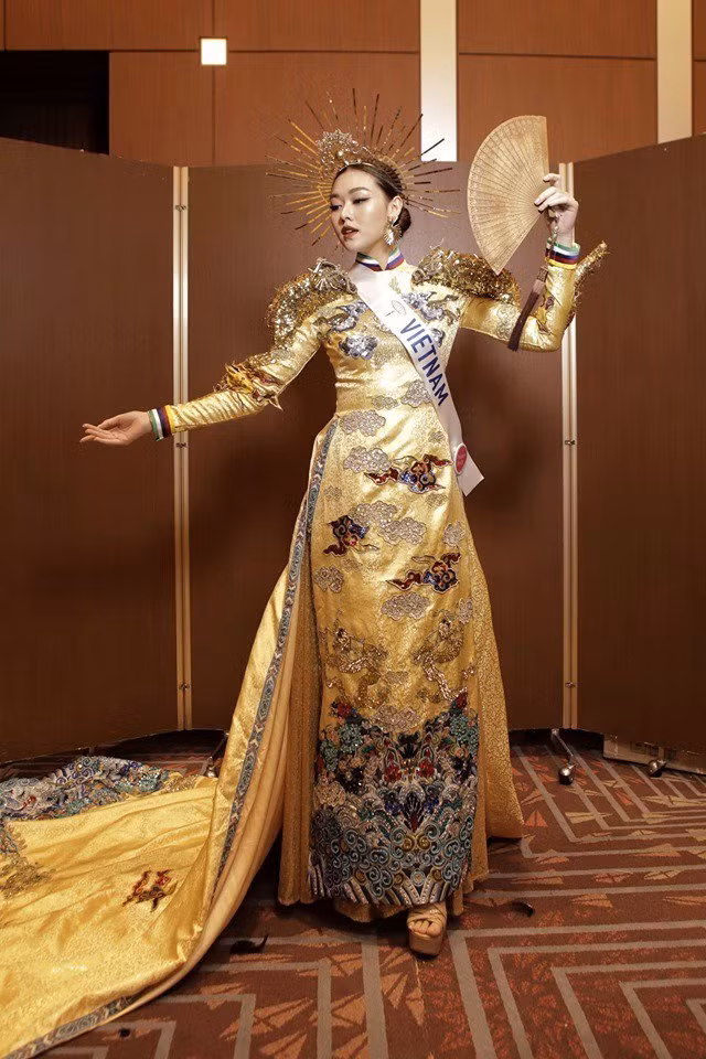  Bộ áo dài quốc phục Việt Nam lấy cảm hứng từ hình ảnh rồng chầu về hướng mặt trời thường thấy trong kiến trúc của người Việt.